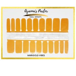 May include: Ayanna's Parlor nail wraps in a marigold color. The nail wraps are arranged on a white card with the text "Ayanna's Parlor" and "Nail Wraps" at the top and "Marigold Vibes" at the bottom.
