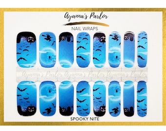May include: Sheet of nail wraps with a Halloween theme. The wraps feature a blue gradient background with black bats, pumpkins, and witch silhouettes. The text "SPOOKY NITE" is printed at the bottom. The brand name "Ayanna's Parlor" is at the top.