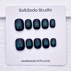 May include: A set of press-on nails in a dark teal color with a glossy finish. The nails are arranged on a white card with the text "SaltSoda Studio" and "HANDMADE WITH LOVE."