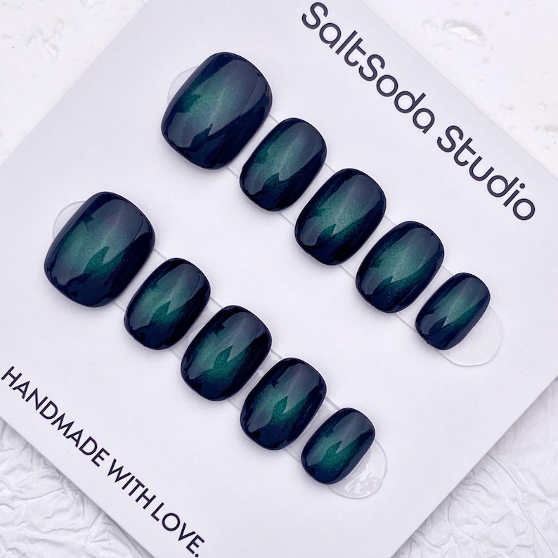 May include: Set of press-on nails in a dark teal color with a glossy finish. The nails are arranged on a white card with the text "SaltSoda Studio" and "HANDMADE WITH LOVE."