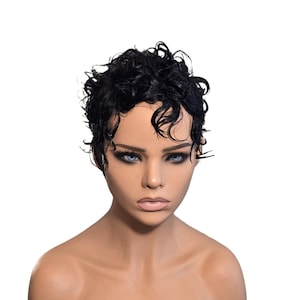 May include: A mannequin head with a short, black, curly wig. The wig has a wet look and is styled in a classic pixie cut. The mannequin has blue eyes, dark eyebrows, and full lips. The background is plain white.