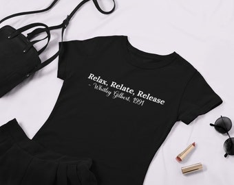 Op de afbeelding: Zwart T-shirt met witte tekst die "Relax, Relate, Release - Whitley Gilbert. 1991" luidt.