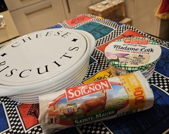 A pamperchef bowl and cheese and biscuit platter white ceramic exterior stoneware interior. very clean. integrated handles. rimmed exterior.