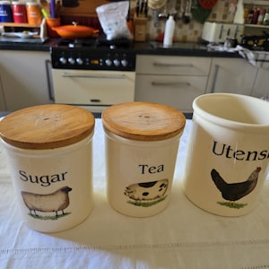 vintage cloverleaf stoneware storage jars sugar tea and utensils wooden lids rustic picture sheep pig and cockeral jars great condition coun