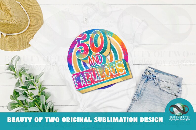 Puede incluir: Una camiseta blanca con un dise&ntilde;o gr&aacute;fico colorido que dice "50 and Fabulous". El gr&aacute;fico presenta un c&iacute;rculo de colores arco&iacute;ris con un contorno dorado y un rect&aacute;ngulo dorado m&aacute;s peque&ntilde;o con el texto "50 and Fabulous" en una fuente colorida.