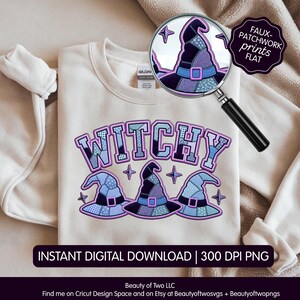 May include: A beige crewneck sweatshirt featuring a graphic with the text WITCHY in a blue and purple faux-patchwork pattern, accompanied by three matching witch hat illustrations. A magnifying glass shows a close-up of the hat design.