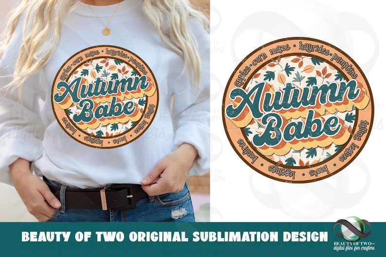 May include: A white sweatshirt with a round, orange and brown graphic design featuring the text "Autumn Babe" surrounded by fall-themed words like "apples", "corn", "hayrides", and "pumpkins".
