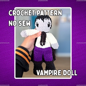 May include: A plush vampire doll made of soft yarn, featuring a grey head with black hair, a white shirt with a black tie, purple pants, and black boots. The text CROCHET PATTERN NO SEW VAMPIRE DOLL is displayed over the image of the handmade toy.