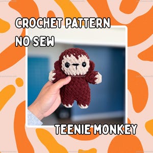 May include: A small, dark brown and beige crocheted monkey plush toy with black safety eyes and a stitched mouth. The text CROCHET PATTERN NO SEW TEENIE MONKEY is displayed around the image. The monkey has a rounded head and body.