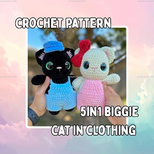 May include: Two crochet cat plushies with large green eyes. The black cat wears a blue hat and blue overalls. The white cat wears a red bow and a pink dress. Text reads CROCHET PATTERN 5IN1 BIGGIE CAT IN CLOTHING. The plushies have a soft texture.