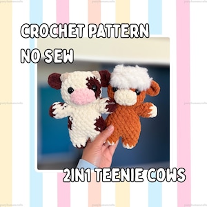 May include: Two small plush cow toys made of soft yarn. One cow is white with brown patches and a pink snout, while the other is solid brown with a white fuzzy patch on its head. The text CROCHET PATTERN NO SEW 2IN1 TEENIE COWS is visible.
