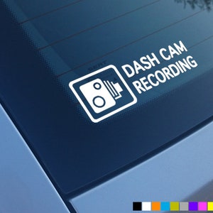 May include: White sticker with the text "DASH CAM RECORDING" and a camera icon on a blue car window.