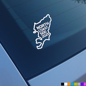 May include: White vinyl sticker of the North Coast 500 route with the text "North Coast 500 2025" on a blue car window.