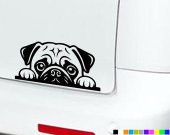 May include: A black vinyl decal featuring a stylized illustration of a pug dog peeking over a straight horizontal edge. The design shows the pug's face, ears, and two front paws resting on the line, rendered in a bold, high-contrast graphic style.