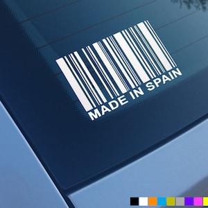 Puede incluir: Pegatina blanca con un código de barras y el texto "MADE IN SPAIN" en una ventana de coche azul.