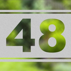 Könnte beinhalten: Ein weißes Quadrat mit einem schwarzen Doppelrahmen, die Zahl 48 ist in Schwarz im Quadrat gedruckt.