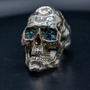 golden skull ring based on argus panoptes the greek one hundred eyed cyclops crushed opal set eyes front view