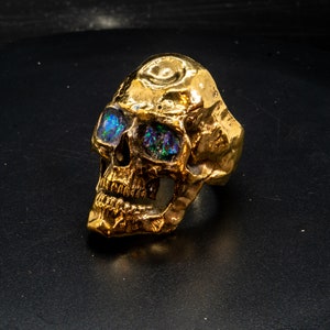golden skull ring based on argus panoptes the greek one hundred eyed cyclops crushed opal set eyes