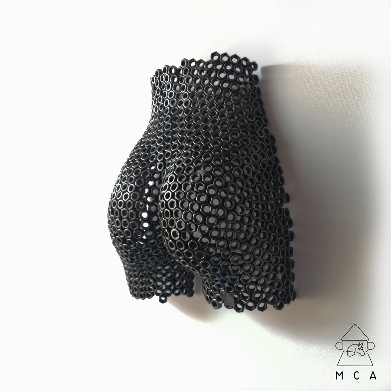 May include: A black metal sculpture of a human body, made entirely of nuts and bolts.