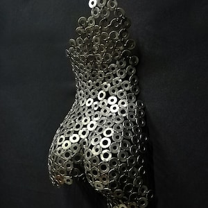 May include: A silver metal sculpture of a human torso made from a collection of small, round metal washers.
