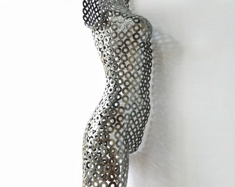 May include: A silver metal sculpture of a human torso made from interlocking metal rings.