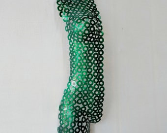 May include: A green metal sculpture of a human torso made of interlocking circles.