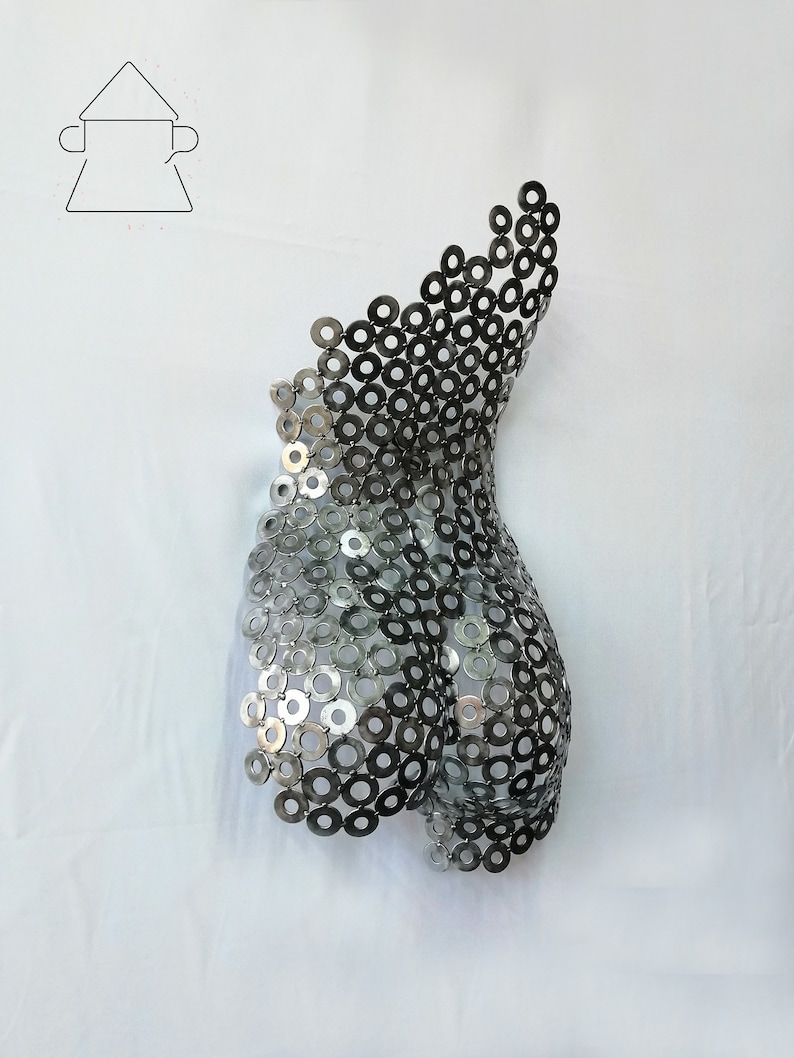May include: A silver metal sculpture of a human torso made from a series of interlocking metal washers.