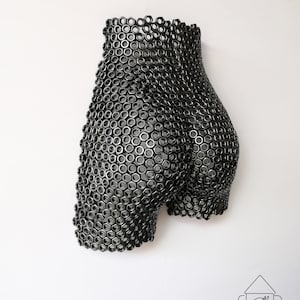 May include: A black metal sculpture of a human form made entirely of nuts and bolts.