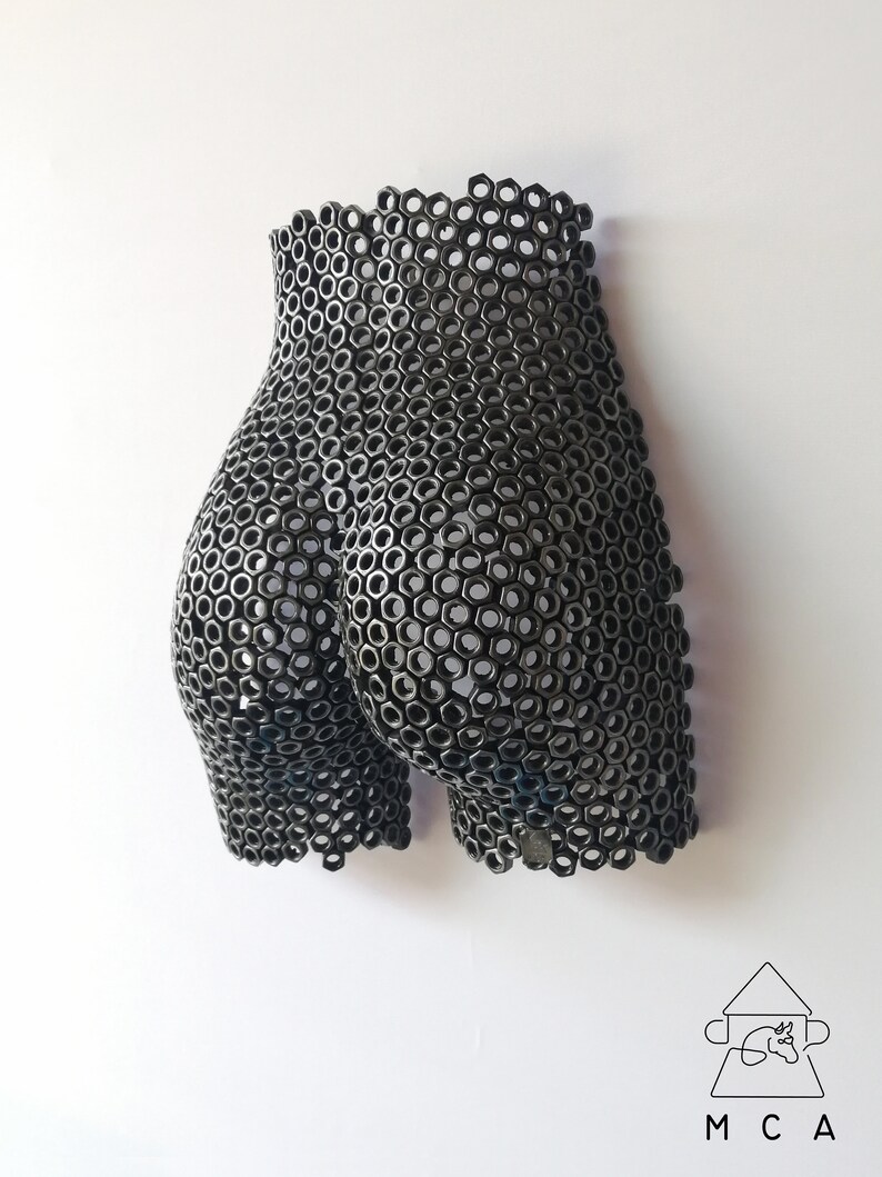 May include: A black metal sculpture of a human form made from hexagonal nuts.