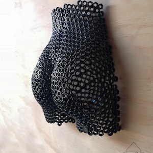 May include: A black metal sculpture of a human form made entirely of hexagonal nuts.