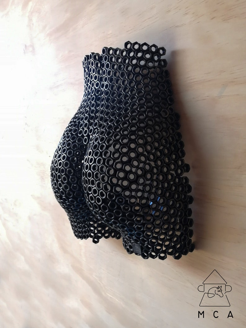 May include: A black metal sculpture of a human form made entirely of hexagonal nuts.