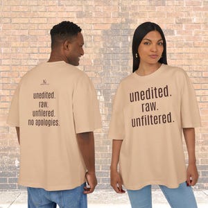 Könnte beinhalten: Zwei Personen tragen beige übergroße T-Shirts. Auf der Vorderseite des Shirts rechts steht "unedited. raw. unfiltered". Auf der Rückseite des Shirts links steht "unedited. raw. unfiltered. no apologies."