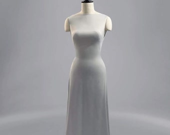 May include: A simple, sleeveless, light gray maxi dress on a mannequin.