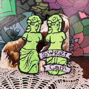 Könnte beinhalten: Zwei grüne gestickte Patches mit dem Bildnis einer Frau und dem Text "Sweet Candy" auf einem lila Banner.