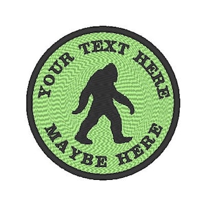May include: A green and black round embroidered patch with a silhouette of Bigfoot walking. The text "YOUR TEXT HERE MAYBE HERE" is written around the edge of the patch.