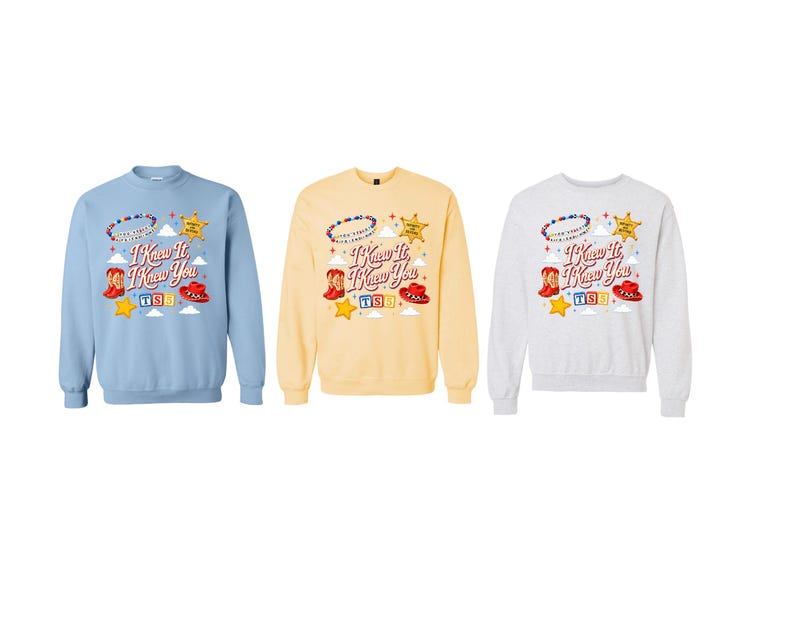 May include: Three crewneck sweatshirts in light blue, pale yellow, and heather grey. Each features a graphic with the text "I Knew It I Knew You," a beaded bracelet, a sheriff badge, cowboy boots, a red hat, and colourful building blocks.