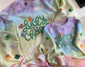 St pattys day lucky charm rainbow tie dye crewneck with arm designs.