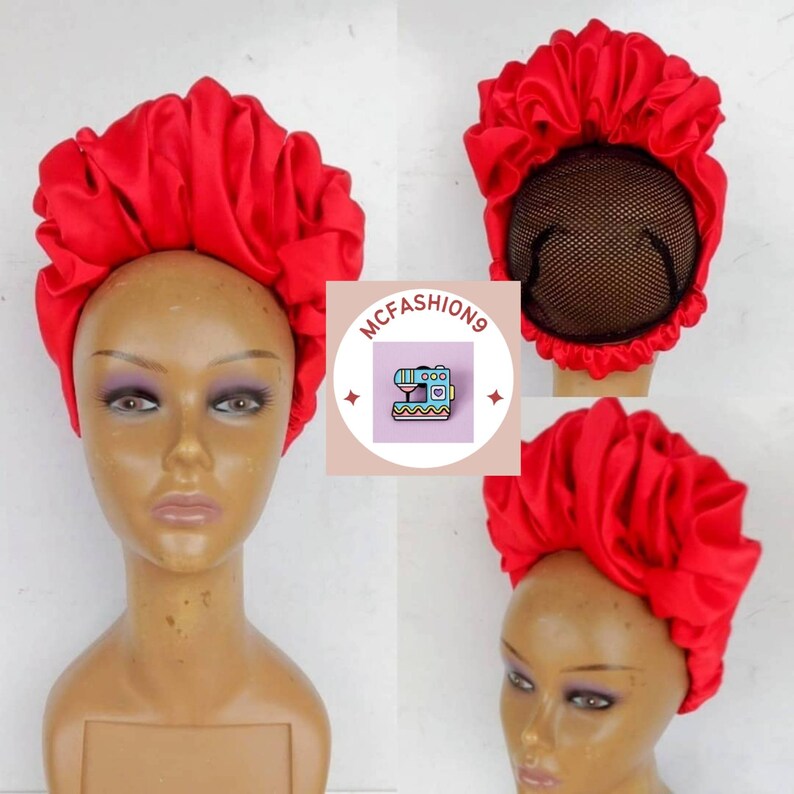 May include: Red satin bonnet with a gathered design. The bonnet is worn on a mannequin head. The bonnet is designed to protect hair while sleeping.