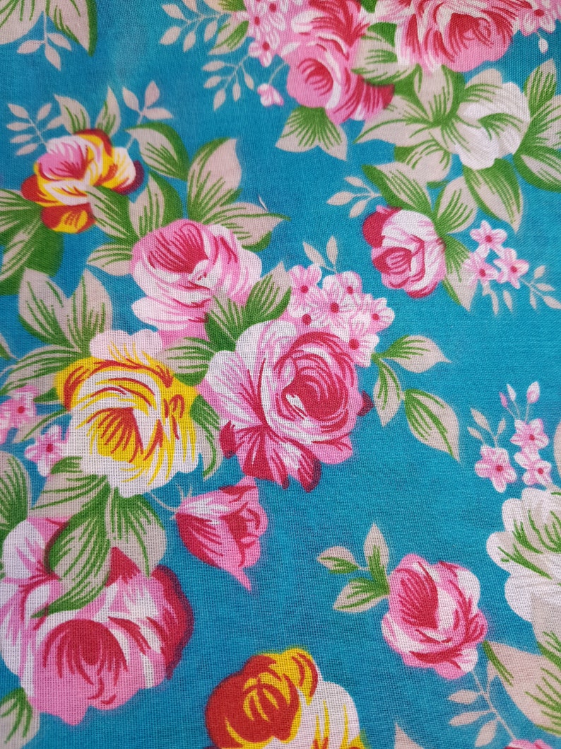 Pu&ograve; includere: Un tessuto turchese con un motivo floreale con rose rosa, bianche e gialle. Il tessuto ha un aspetto vintage e sarebbe perfetto per progetti di artigianato.