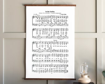 May include: A black and white printable wall art featuring the hymn "In the Garden" with sheet music and lyrics. The text includes the words "Copyright 1912 by Hall-Mack Co. International copyright secured C. Austin Miles."