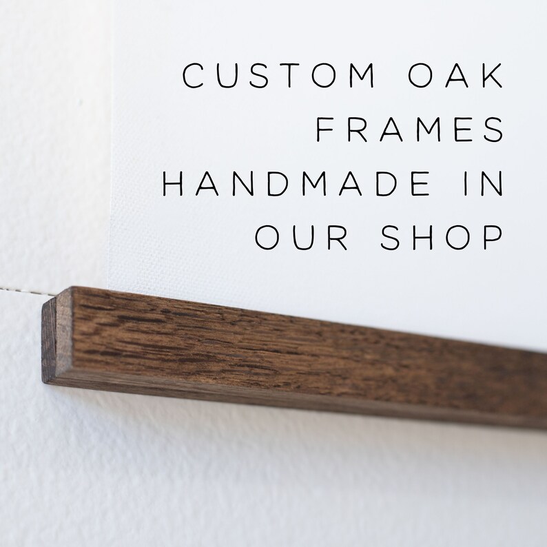 May include: A close-up of a dark brown wood frame with the text "CUSTOM OAK FRAMES HANDMADE IN OUR SHOP" printed on a white background.
