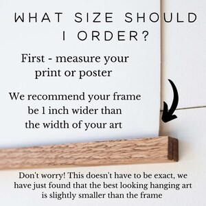 Pu&ograve; includere: Testo su sfondo bianco che spiega come misurare una stampa o un poster per l'incorniciatura. Il testo dice "WHAT SIZE SHOULD I ORDER? First - measure your print or poster. We recommend your frame be 1 inch wider than the width of your art. Don't worry! This doesn't have to be exact, we have just found that the best looking hanging art is slightly smaller than the frame."