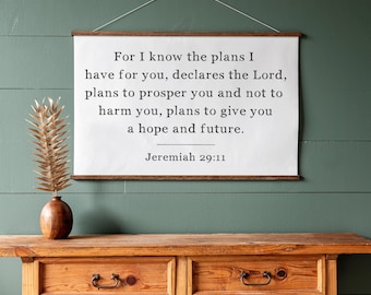 May include: A white canvas print with a wood frame hanging on a green wall. The print features a bible verse from Jeremiah 29:11, "For I know the plans I have for you, declares the Lord, plans to prosper you and not to harm you, plans to give you a hope and future."