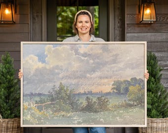 May include: A rectangular landscape wall art piece in a light wood frame featuring a painted scene of a grassy field, trees, and a cloudy sky. The artwork includes faint cursive text overlaid on the center of the sky and landscape imagery.