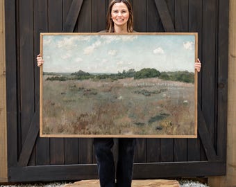 May include: A rectangular landscape wall art piece in a light wood frame featuring a muted field under a cloudy sky. The artwork includes the printed text: Be still, and know that I am God. Psalm 46:10, centered over the grassy meadow scenery.