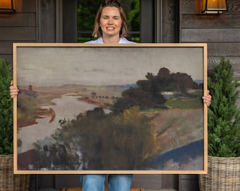 May include: A rectangular landscape painting in a light wood frame depicting a river winding through a muted, earthy countryside with dark trees, rolling hills, and a cloudy sky. The artwork features soft, blended brushstrokes in shades of brown, green, and grey, capturing a serene, natural scene with a focus on the horizon and the flowing water.