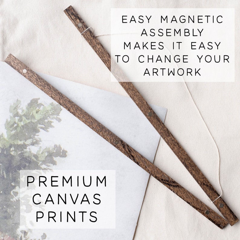 May include: Two wooden rods with magnetic ends, a white string, and a canvas print with a watercolor painting of a tree. The text "EASY MAGNETIC ASSEMBLY MAKES IT EASY TO CHANGE YOUR ARTWORK" is printed above the rods. The text "PREMIUM CANVAS PRINTS" is printed below the canvas print.