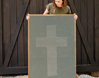 Könnte beinhalten: Ein großes rechteckiges Wandbild mit salbeigrünem Hintergrund und einer Kreuzform, die aus kleinem weißem Text besteht. Das Kunstwerk ist in einem einfachen Holzrahmen gefasst und zeigt eine dichte Anordnung geschriebener Wörter in Kreuzform.