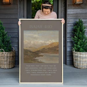 May include: A framed print with a landscape painting of a lake and mountains. The print has the text "ISAIAH 41:10" at the top and a bible verse below the painting. The verse reads "Fear not, for I am with you: be not dismayed, for I am your God: I will strengthen you, I will help you, I will uphold you with my righteous right hand."