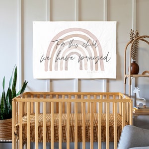May include: A nursery wall tapestry with a watercolor rainbow design and the text "For this child we have prayed" with the scripture reference "1 Samuel 1:27".